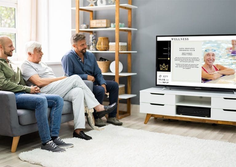Senior Woman with Sons watching Sentrics Engage Solution on TV