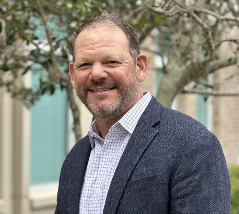 Image of chief operating officer smiling wearing suit