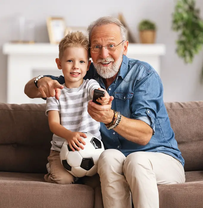 Senior man with grandson watching tv