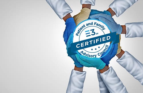 Multiple hands in medical gloves and lab coats placed together over a globe with a patient and family advisory council certified badge overlay.